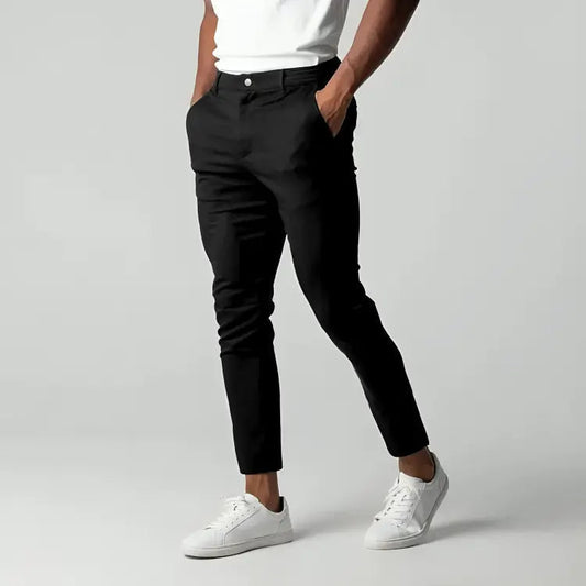 Pantaloni chino blu scuro da uomo, eleganti e moderni, abbinati a scarpe da ginnastica bianche. Ideali per look casual e formali.